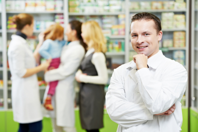 cheerful pharmacist chemist man standing in pharmacy drugstore